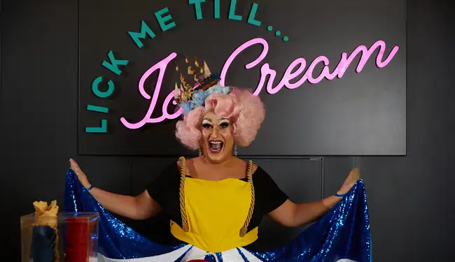 The Diva in front of Lick Me Till Ice Cream, onboard Virgin Voyages ship