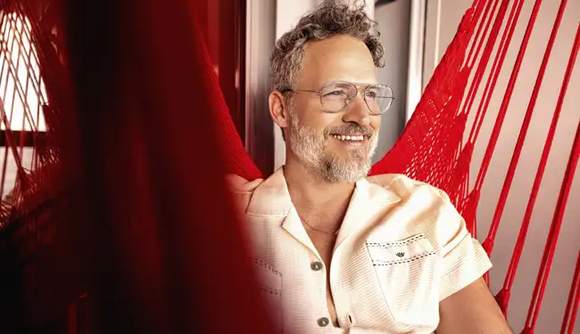 A man relaxing in Virgin Voyages' signature balcony hammock
