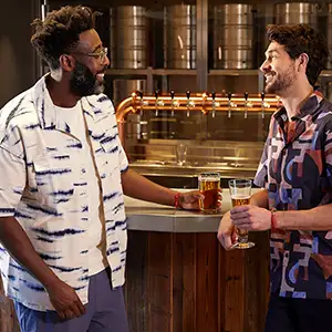 A black bear and white otter chatting in a bar on a Virgin Voyages ship