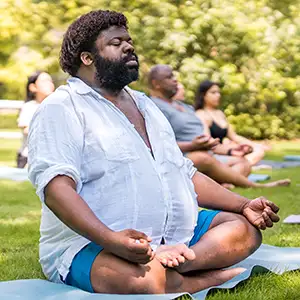 A large black man meditating or doing yoga