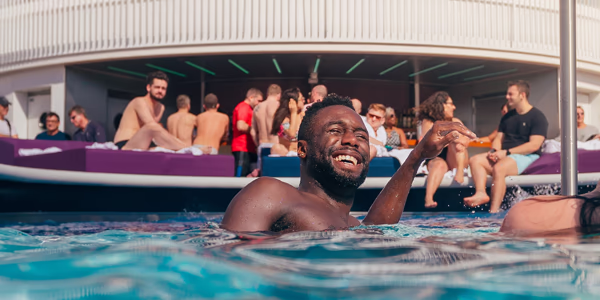 Guy hanging out in the Virgin Voyages pool